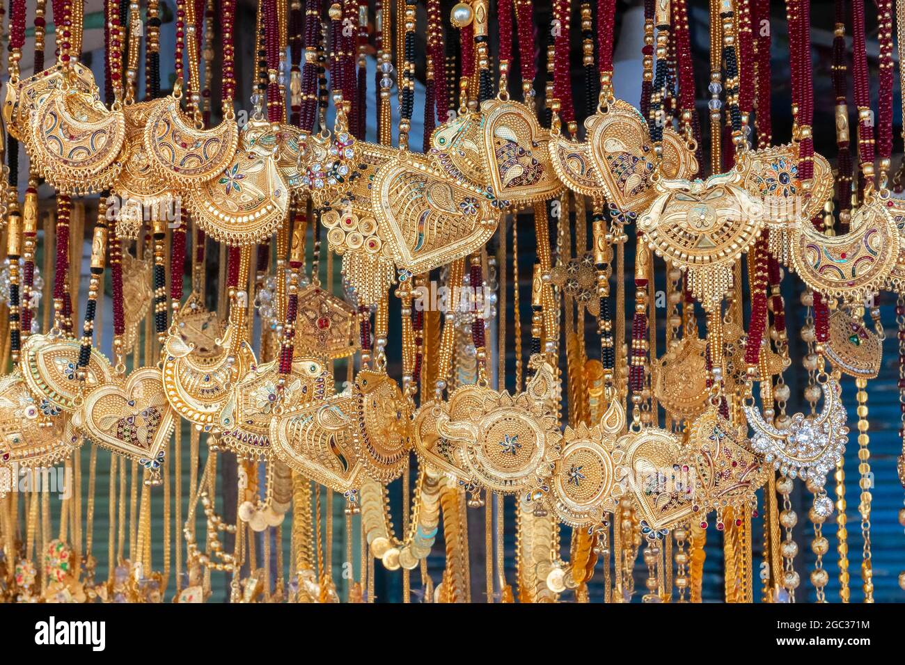 Auspicious gold plated neck pieces are hanging for sale to Indian Bengali women, at Kalighat, Kolkata , West Bengal, India. In Hinduism, gold symboliz Stock Photo