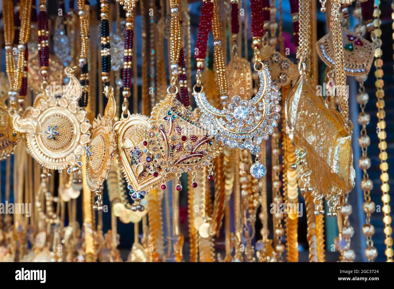 Auspicious gold plated neck pieces are hanging for sale to Indian Bengali women, at Kalighat, Kolkata , West Bengal, India. In Hinduism, gold symboliz Stock Photo