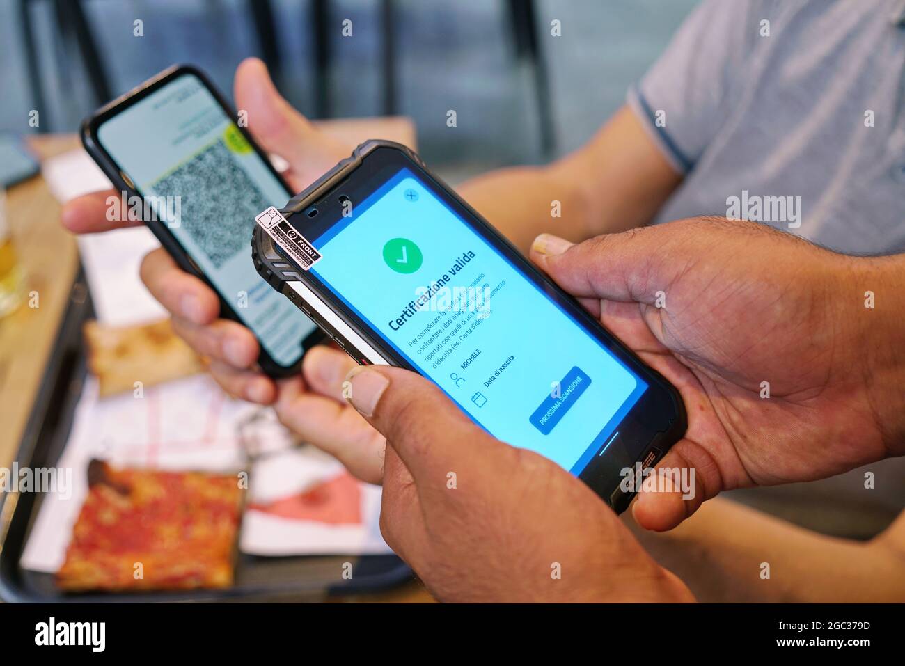 Positive green pass check on smartphone, required for indoor tables in restaurants and bars Selective focus  Turin, Italy - August 2021 Stock Photo