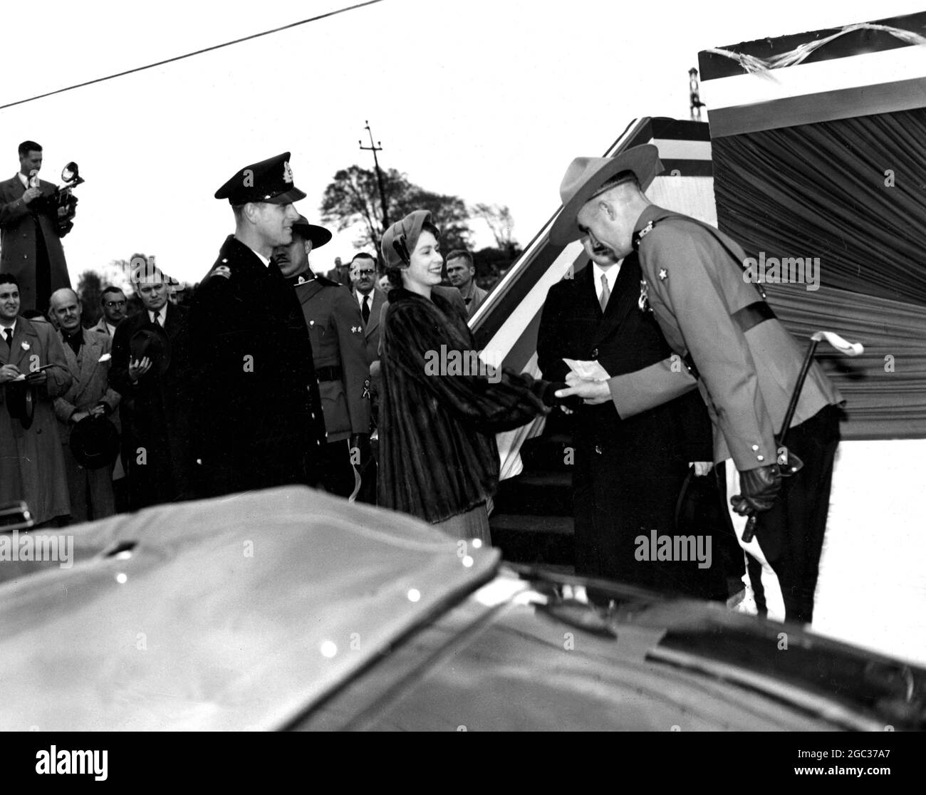 Princess Elizabeth and the Duke of Edinburgh pause to shake hands with an R.C.M.P Officer as they board the train which took them from Dorval Airport to Quebec City. Montreal, Canada - 1951. Stock Photo