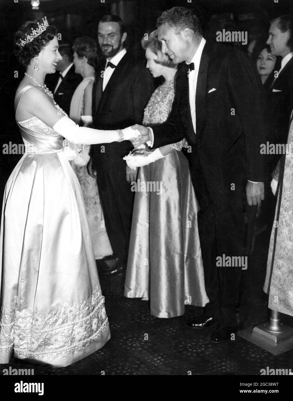 Her Majesty The Queen Elizabeth II at film premiere shakes hands with Anthony Quayle one of the stars in the the film The Guns of Navarone 27 April 1961 Stock Photo