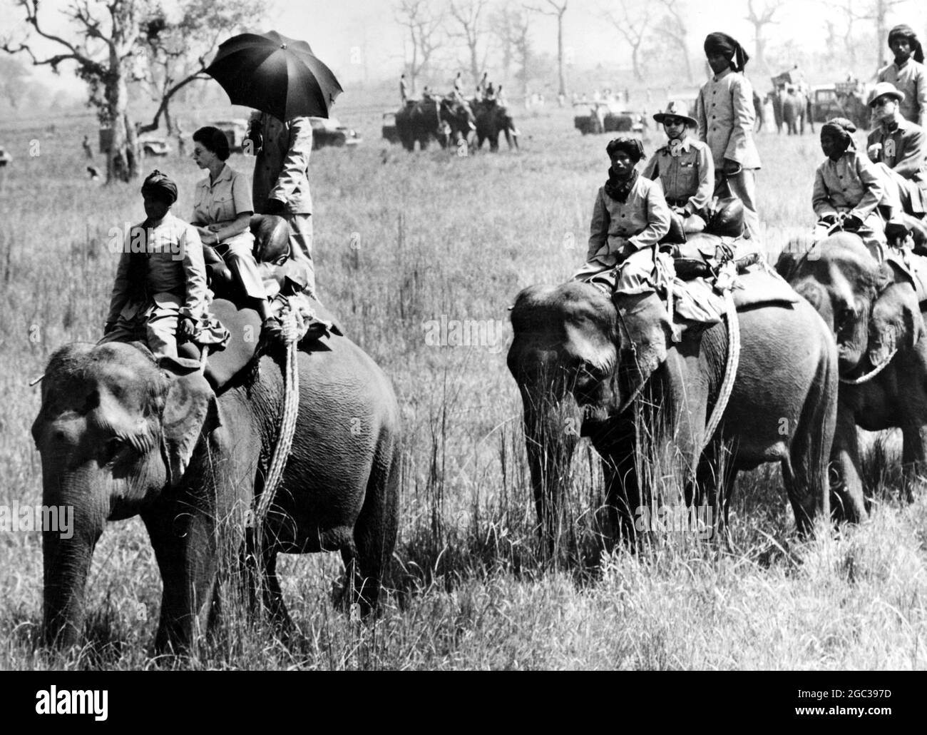 The Queen Elizabeth II sits astride an elephant and is sheltered