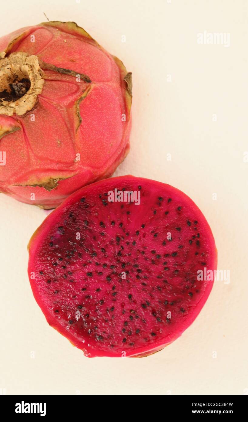 Vertical image of dark pink dragon fruit or pityaya against white background Stock Photo