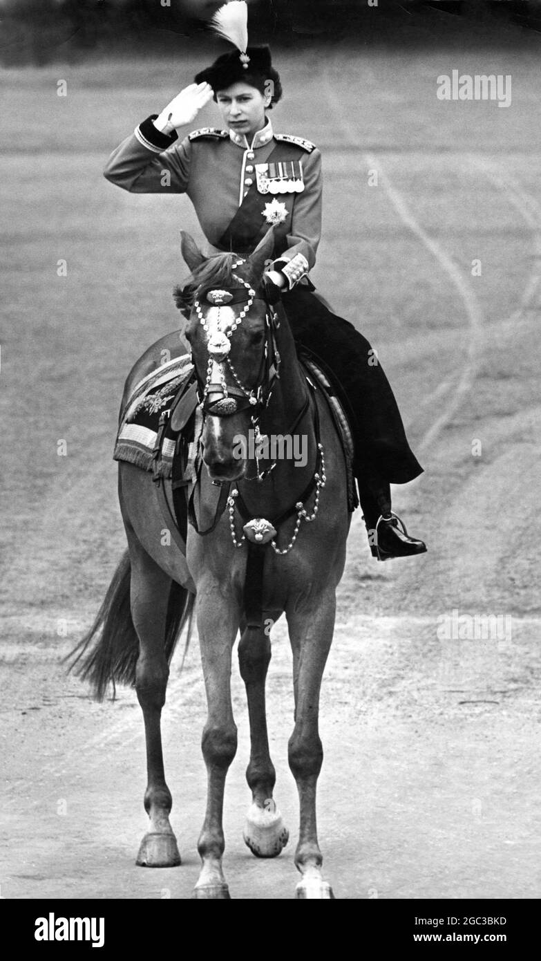 Queen Elizabeth II represents the King for the ceremony of Trooping the Colour of the Third Battalion Grenadier Guards on Horse Guard Parade London She is seen in a new scarlet uniform in Guards Officer Style with a plumed hat Her sash is of the Order of the Garter. Her horse is called Winston The Princess rode side saddle 7 June 1951 Stock Photo