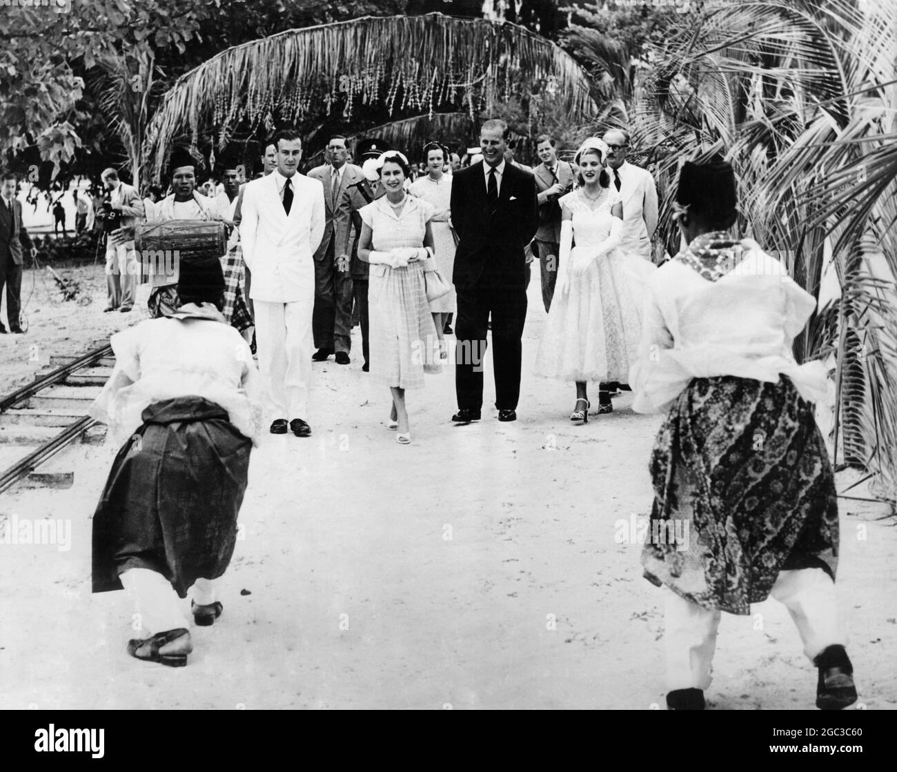 Queen Elizabeth II and the Duke of Edinburgh greeted by a welcome dance performed by natives of the Cocos Islands with Mr and Mrs Clunies Rose April 1954 Stock Photo