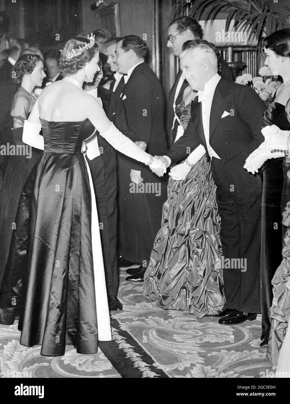 Tonight her Majesty the Queen accompanied by her husband the Duke of Edinburgh and her sister Princess Margaret, attended the royal command film performance in aid of various charities. The film was ‘ Because you are mine' starring Mario Lanza. Her Majesty has Charles Chaplin presented to her before the show. Behind the Queen is Princess Margaret and on Chaplin’s left is his wife . 27th October 1952 Stock Photo