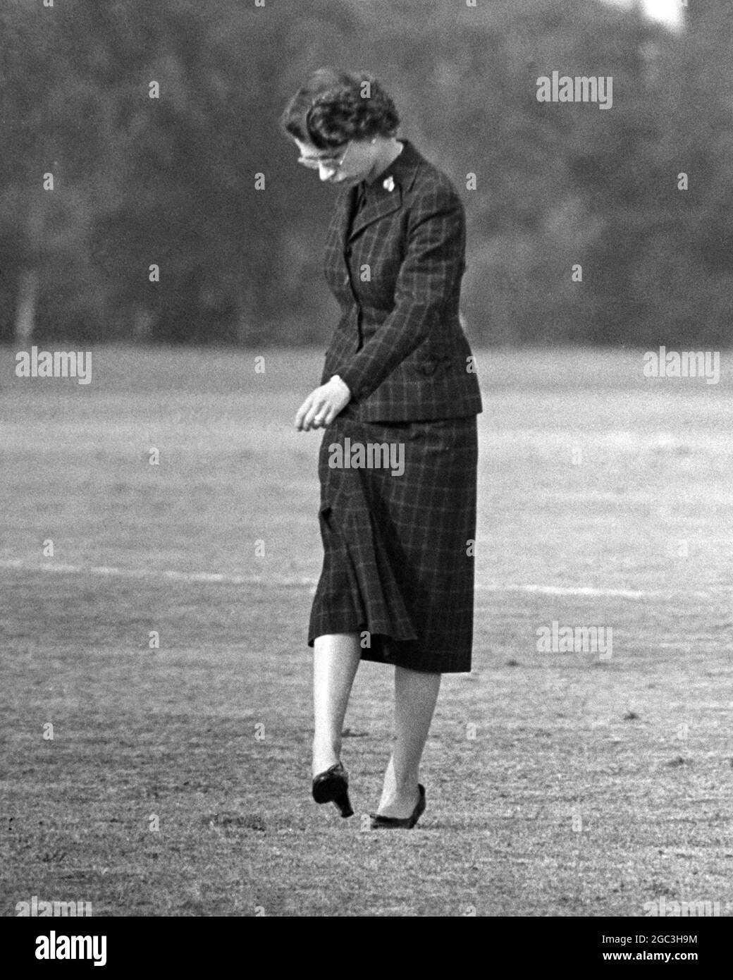 Queen Stamps Down Divots Her Majesty The Queen joins spectators in stamping down holes in the pitch after the Household Brigade Polo Match during the Ascot Week Tournament on Smiths Lawn, Windsor Great Park. 13th June 1955 Stock Photo