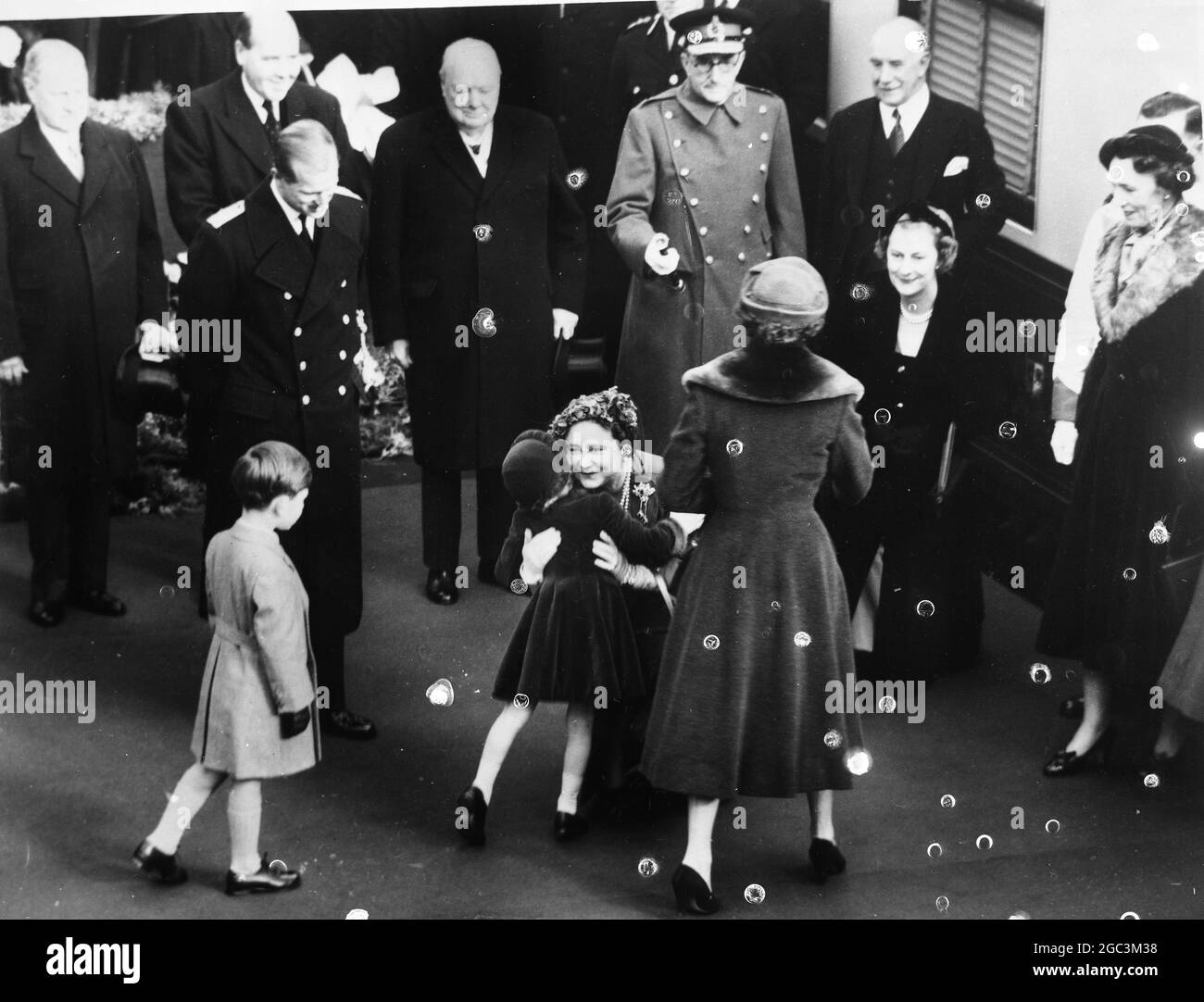 A Hug For Princess Anne From the Queen Mother . Her Majesty , the Queen Mother , back home after her tour of Canada and the USA , hugs her granddaughter , Princess Anne at Waterloo Station on her arrival from Southampton . Looking on are Prince Charles , the Queen , the Duke of Edinburgh with Sir WInston Churchill in the centre . 29th November 1954 Stock Photo