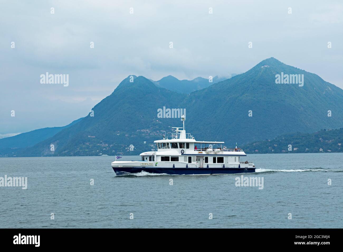 excursion boat passing Monte Sasso del Ferro, Lake Maggiore, Lombardy, Italy Stock Photo