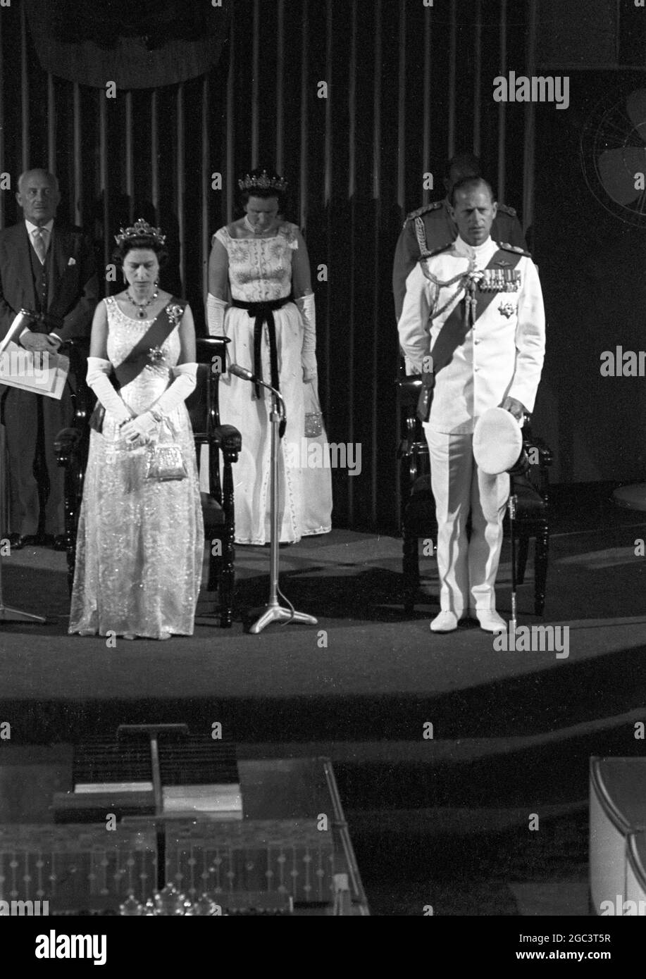 Queen opens Jamaican Parliament . HM Queen Elizabeth II with Prince Philip, Duke of Edinburgh beside her formerly opens the Jamaican Parliament in Gordon House, Kingston during the Royal three-day visit to Jamaica . Seen in the background left to right are Sir Michael Adeane , the Queen's Private Secretary ; Lady-in-waiting Marchioness of Abergavenny and Jamaican Equerry Major Trevor Robinson 8 March 1966 Stock Photo