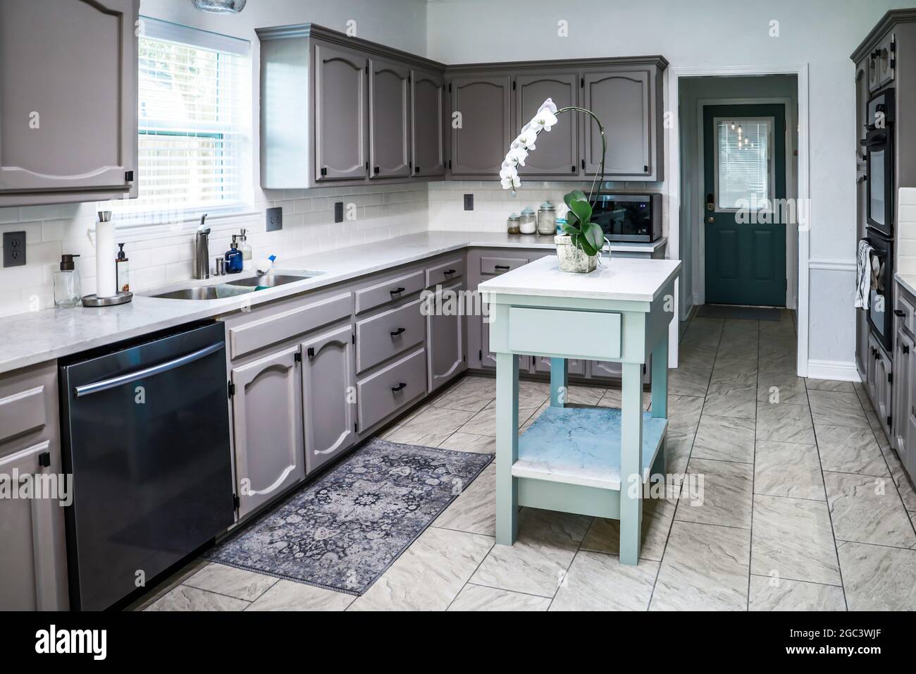 Compact kitchen with a small table and a comfortable cooking surface with  modern appliances and wall cabinets with floral wallpaper. Kitchen concept  Stock Photo - Alamy