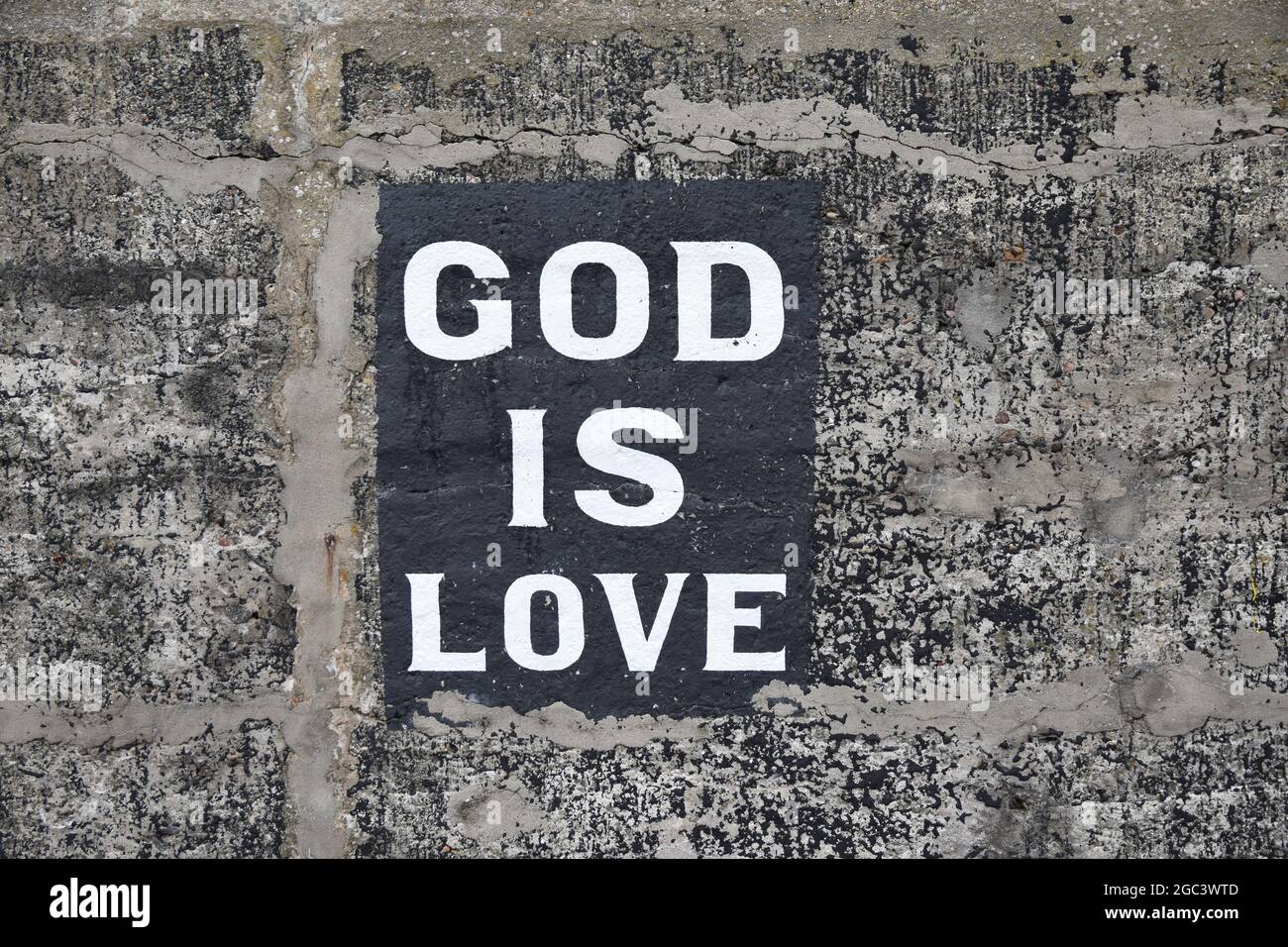 God is love sign painted on harbour stone wall. Isolated, no people. Stock Photo