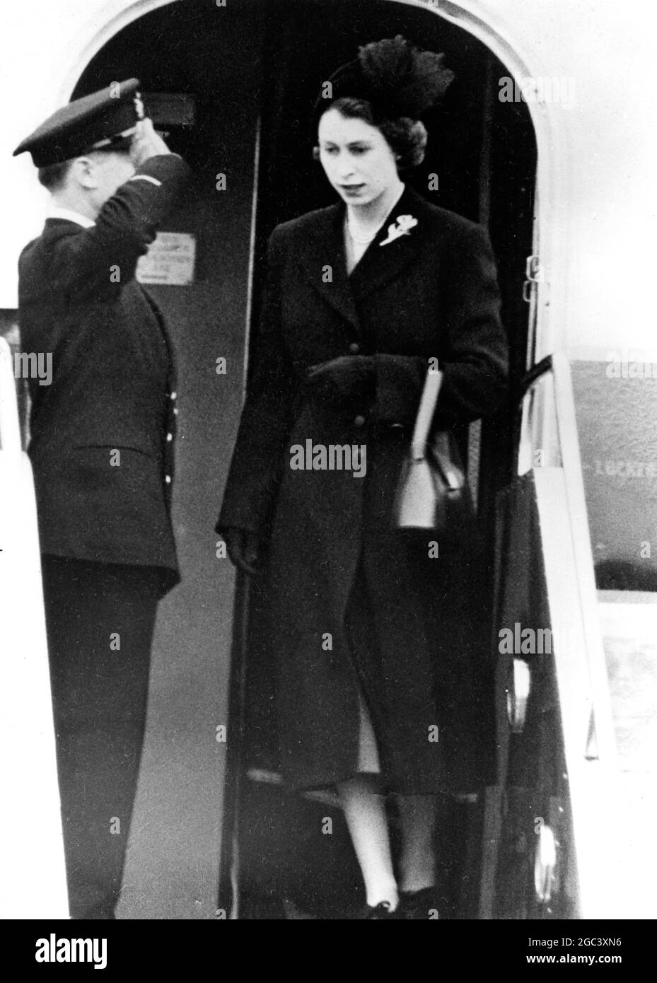 Princess Elizabeth , who left England last week with the Duke of Edinburgh on their Commonwealth Tour , returned to London Airport today from Kenya as Queen Elizabeth II . The royal couple had cut short their Commonwealth tour because of the King's death . Government and Opposition ministers , looking very sad as they mourned the passing of King George VI , were at the airport to officially welcome the new Queen . Seen here alighting from the plane . 7 February 1952 Stock Photo