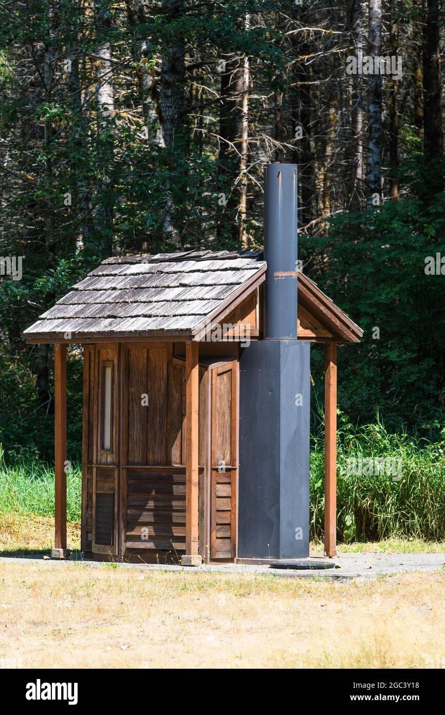 Randle, WA, USA - August 04, 2021; A wooden outhouse with a meatal vent pipe in the Gifford Pinchot National Forest in Southwest Washington State Stock Photo