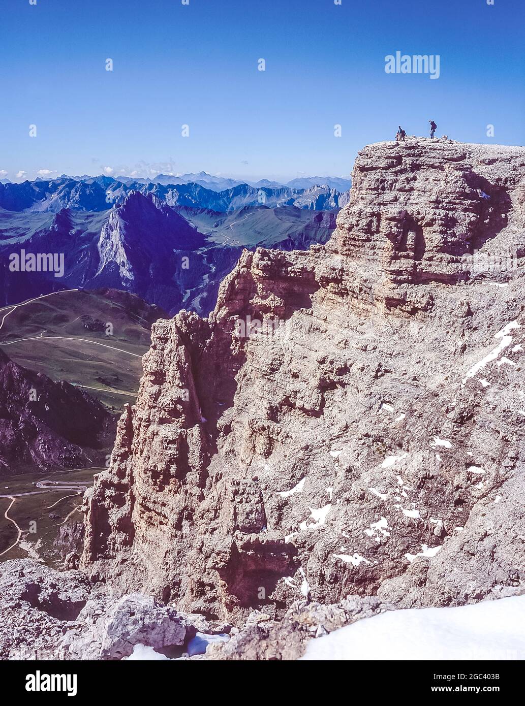 This is the summit cross on Piz Boe 3152m the highest mountain in the Sella Group of mountains in the Italian Dolomites of the Alto Adige of the Sud Tyrol looking across the Sella plateau to the dramatic three peaks of Langkofel and north to mountains of the Austrian Alps Stock Photo