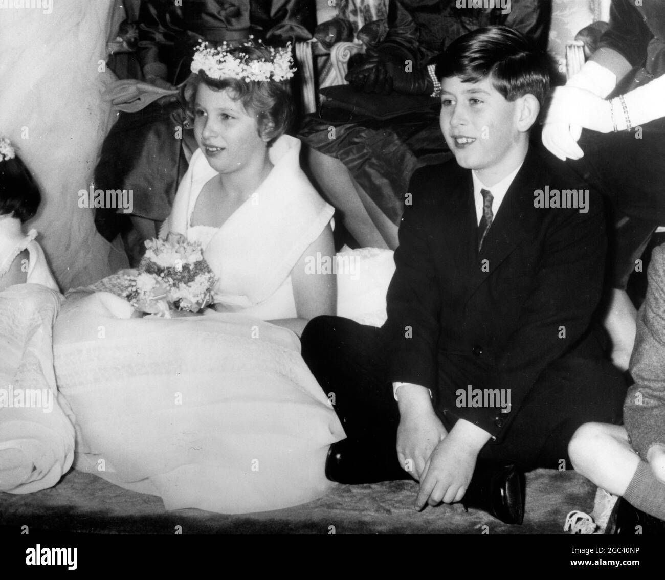 Princess Anne a bridesmaid sitting with Prince Charles, cross legged on the floor. This was Princess Anne's first public duty when she was bridesmaid to Lady Pamela Mountbatten. Lady Pamela married Mr David Hicks, at Romsey Abbey, Hants. 13 January 1960 Stock Photo