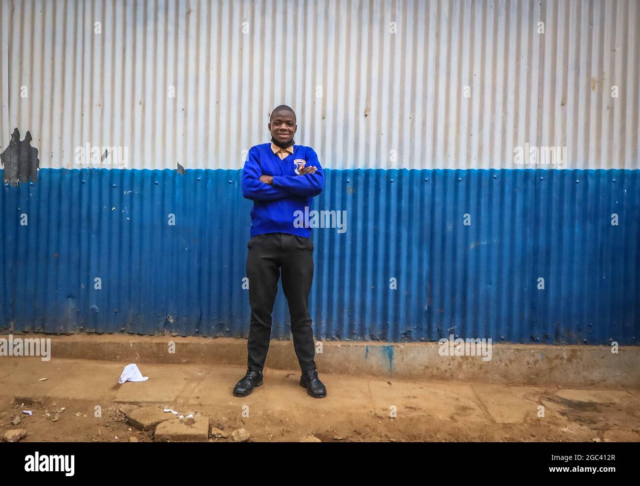 The 18-year-old Saviour Omondi, a local artist takes a photo outside his school compound in Raila Educational Centre in Nairobi.An 18-year-old artist born and raised in Kibera, from a family of five, he began his love for art back in 2009 by copying and learning most skills from his dad who was doing art but not to a professional level. Omondi’s main focus was to portray his home through his artwork and dreamt of making the best out of his art in the future after his studies. Stock Photo