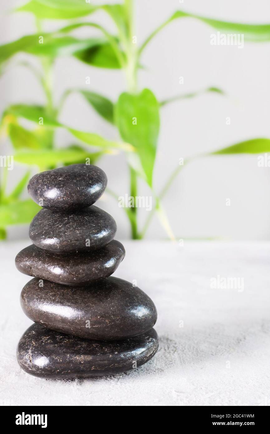 Black zen stones in a stack on white background with bamboo Stock Photo ...