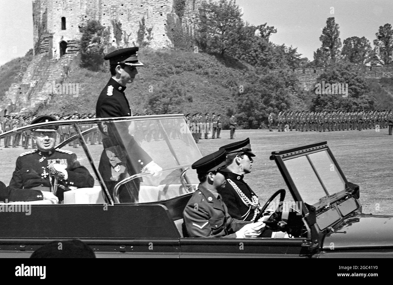 Prince Charles stand in an open car, wearing his investiture uniform for the first time here today, when he presented the colours at the Inauguration of the Royal Regiment of Wales, and accepted the Freedom of the City on behalf of the Regiment. The uniform, which is dark blue, is the one he wears as new Colonel in Chief of the Royal Regiment, and the one he will wear at his Investiture as the Prince of Wales at Caernavon Castle on 1 July 1969. At the Inauguration Ceremony, the South Wales Borderers and The Welsh Regiment were amalgumated into one regiment. Cardiff Castle Green , Cardiff, Wale Stock Photo