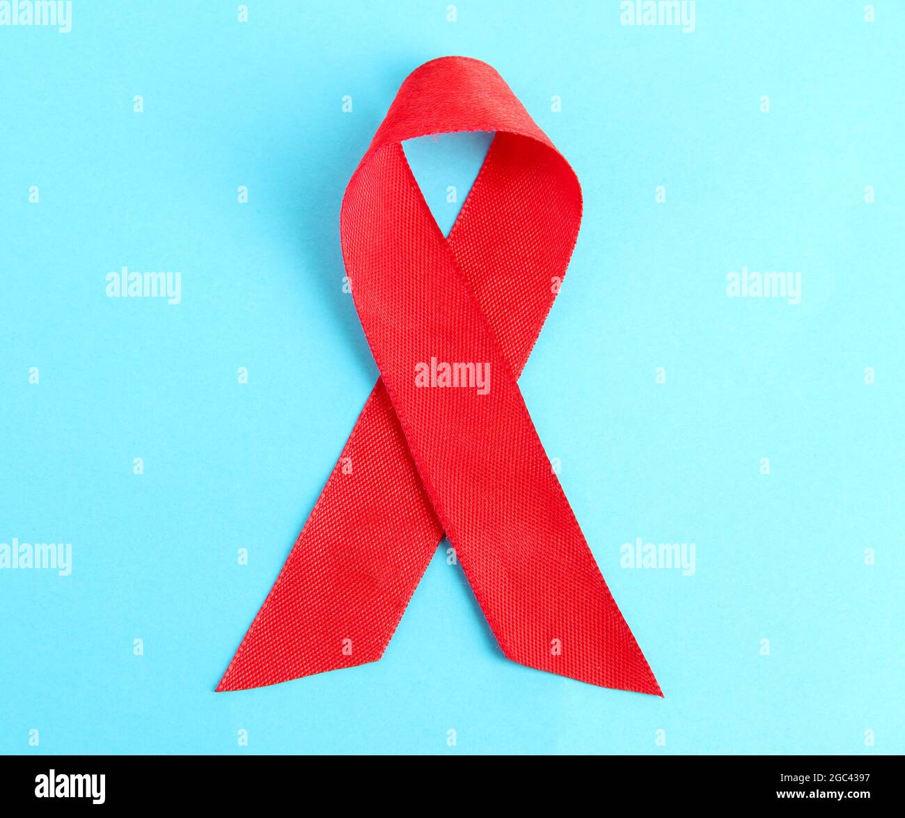 Red ribbon HIV, AIDS on blue background Stock Photo - Alamy