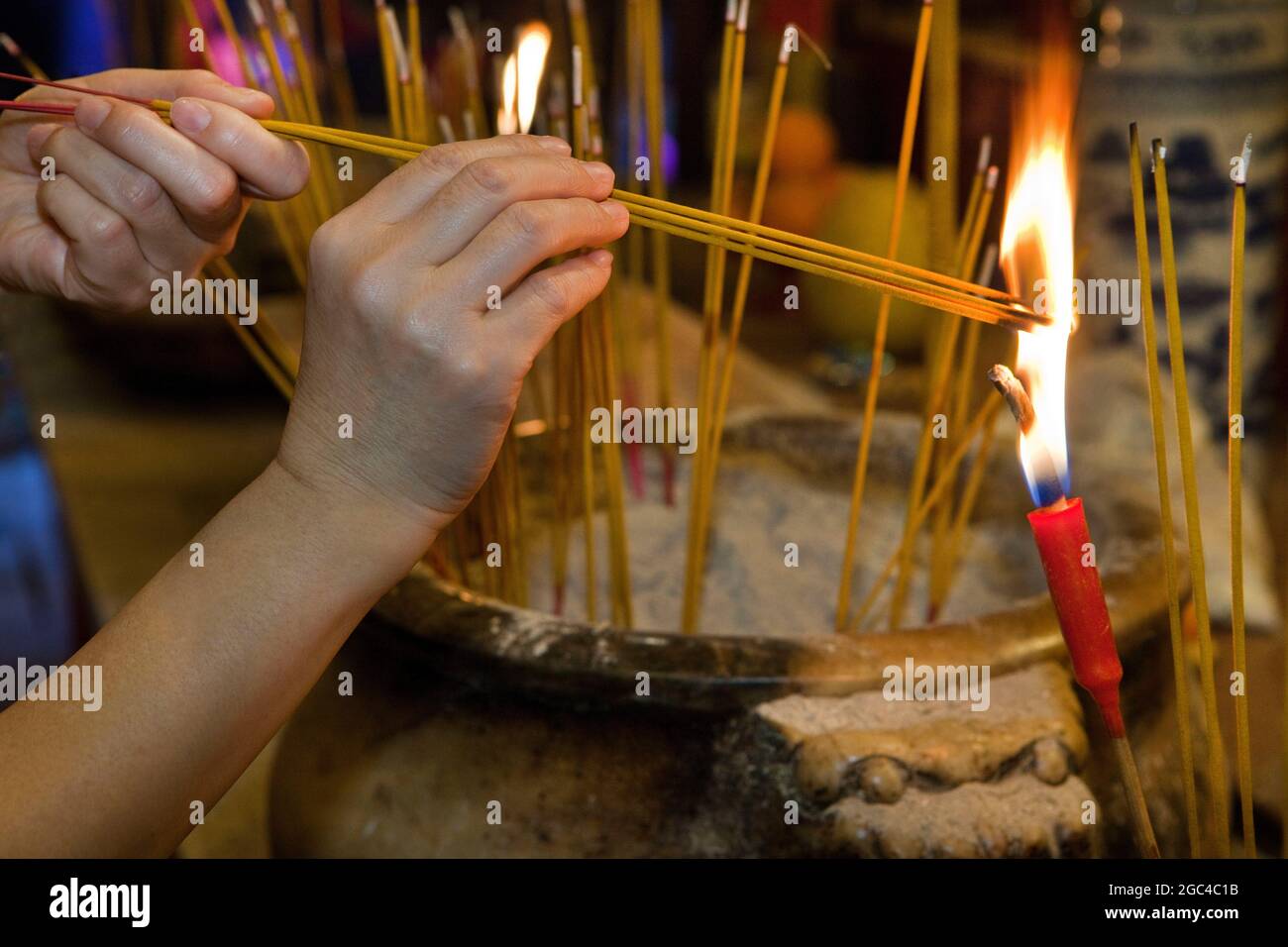 Worshiper lights incense at Man Mo Temple in Hong Kong, China Stock Photo