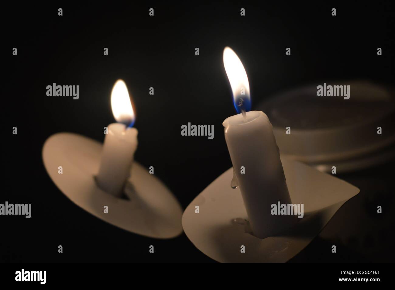 A focused photo on somber, beautiful photo of two candles from a candlelight vigil around Christmas time. Stock Photo