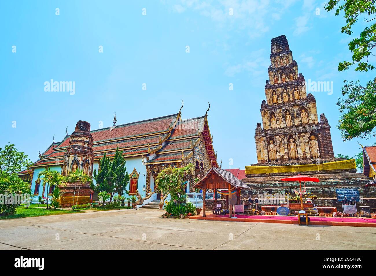 The splendid ancient Wat Chammathewi Temple with ruins of Ratana Chedi (stupa from the left) and Suwan Chedi Chang Kot (Jungkote) with Buddhas in nich Stock Photo
