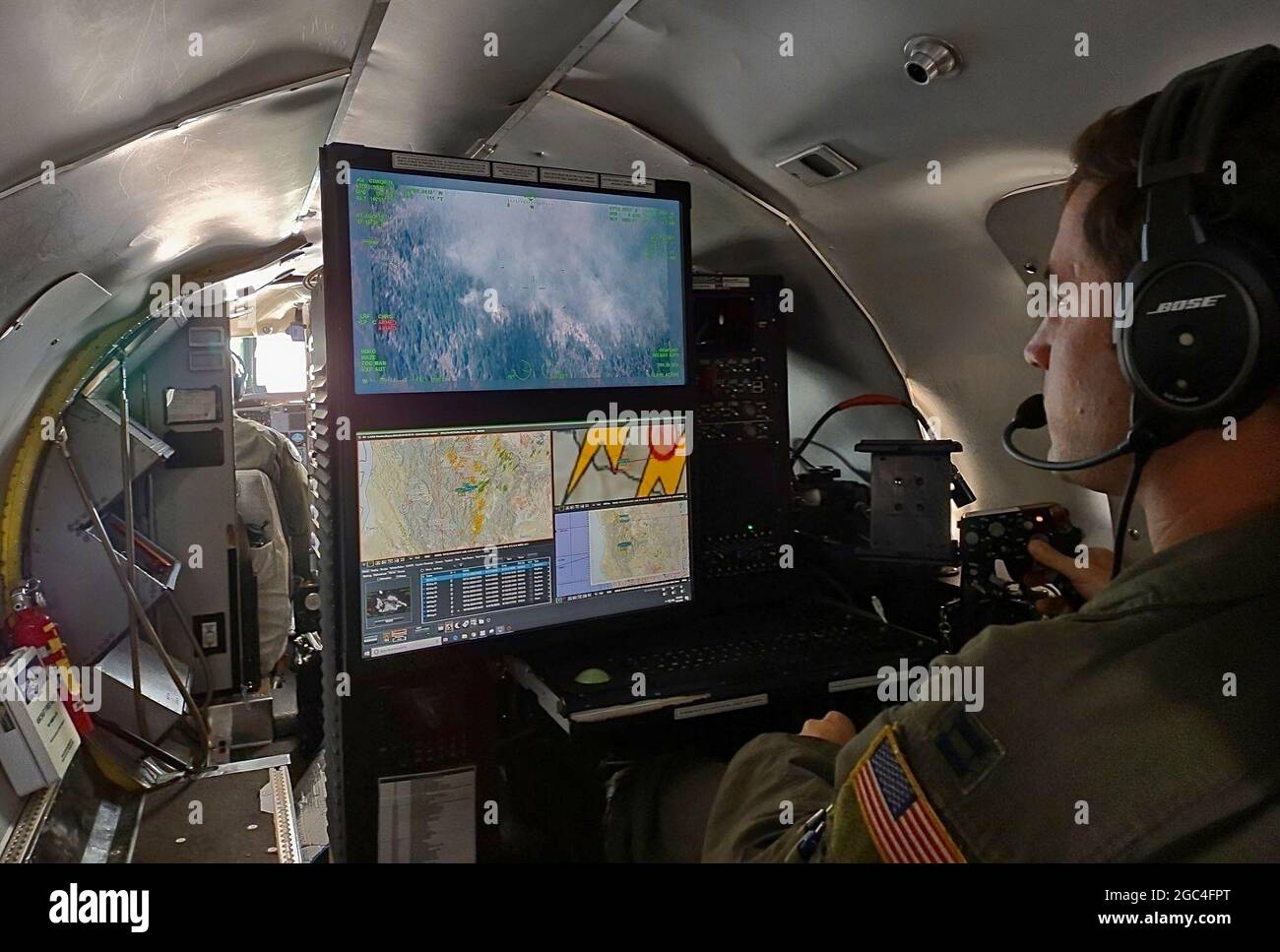 Capt. Alex McArdel, 141st Air Refueling Wing RC-26B aircraft mission systems officer, uses the aircraft's camera to map and detect wildland fires in the north-western region of the United States, August 1, 2021. The RC-26 is tasked with utilizing its highly mobile platform by making infrared images and video of the fires from above in order to map and detect wildland fires and hotspots in the western region of the United States. The RC-26 crews can detect hotspots from up to 60 nautical miles away before they become fires and help direct teams to those locations. First Air Force (Air Forces No Stock Photo