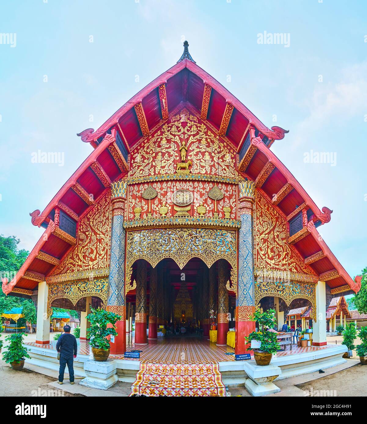 Spectacular facade of Viharn Luang of Wat Phra That Lampang Luang Temple with gilt patterns, three-tired pyathat roof, carvings and teak pillars, Lamp Stock Photo