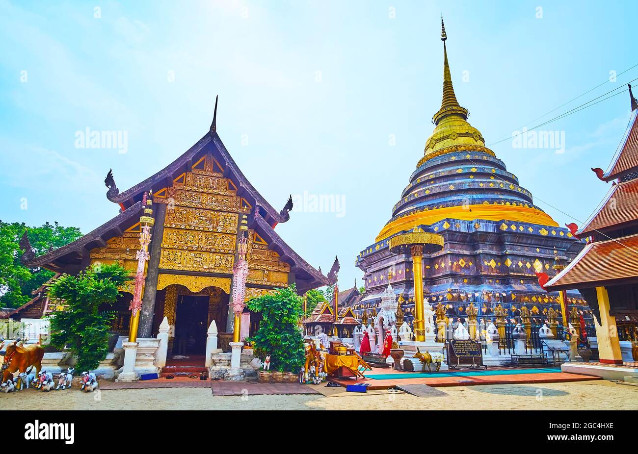 The facade of historic Viharn Laikham (Viharn Phra Put) and the copper chedi of Wat Phra That Lampang Luang, Lampang, Thailand Stock Photo