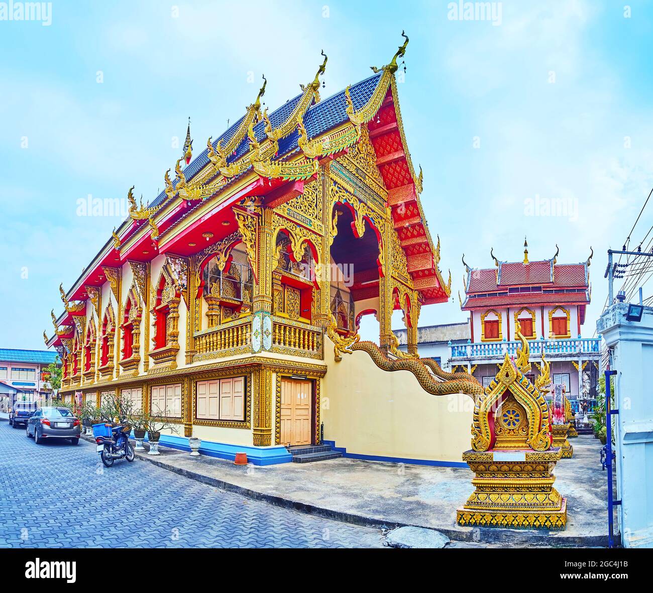 Historic building of Ubosot of Wat Chai Mongkhon Temple with amazing gable (pyathat) roof, carved bargeboards, chofas (roof decors) and facade, Lamphu Stock Photo