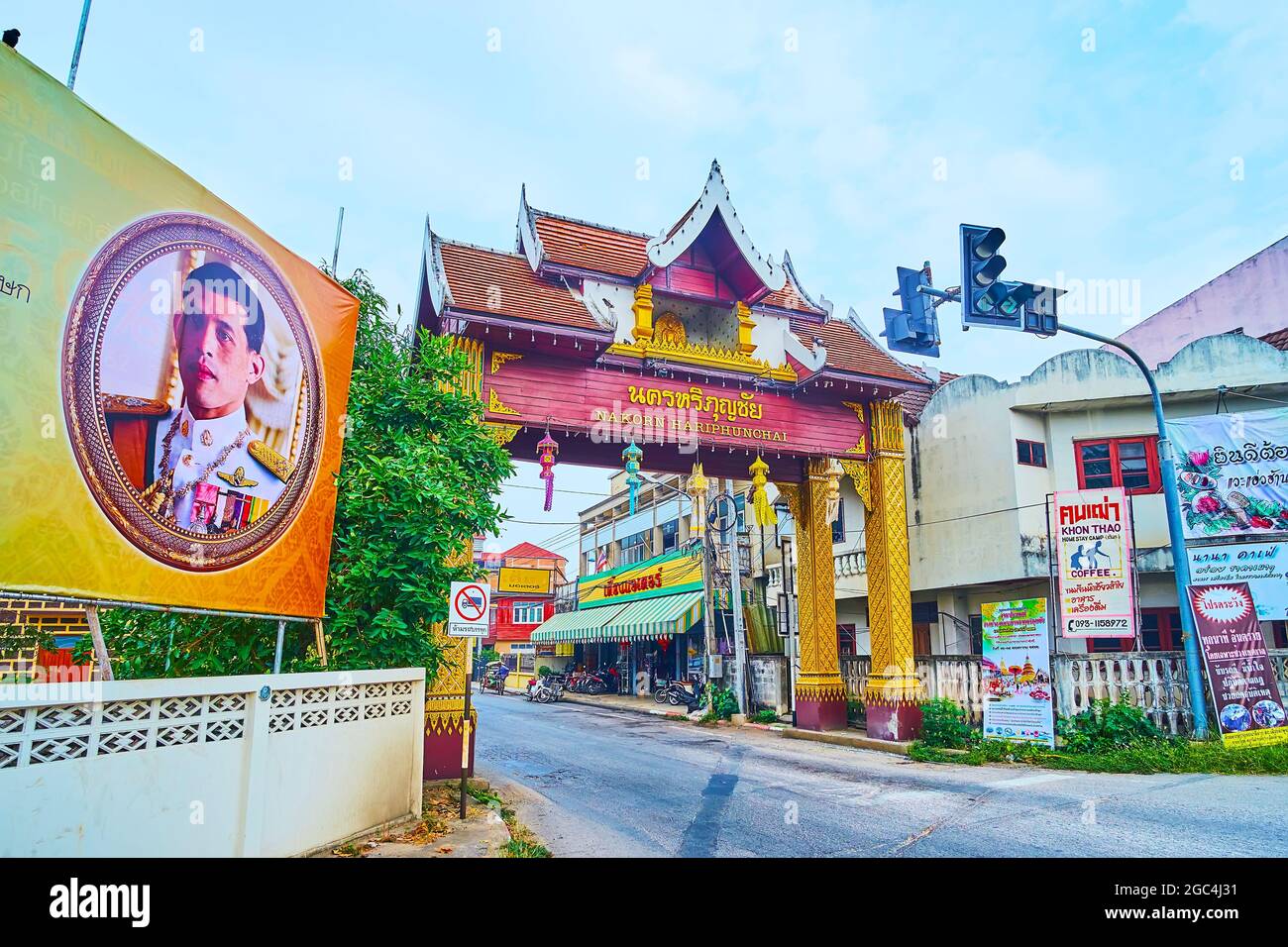 LAMHPUN, THAILAND - MAY 8, 2019: Traditional old town gate with pyathat roof, gilt columns, covered with fine Thai pattern and inscription 'Nakorn Har Stock Photo