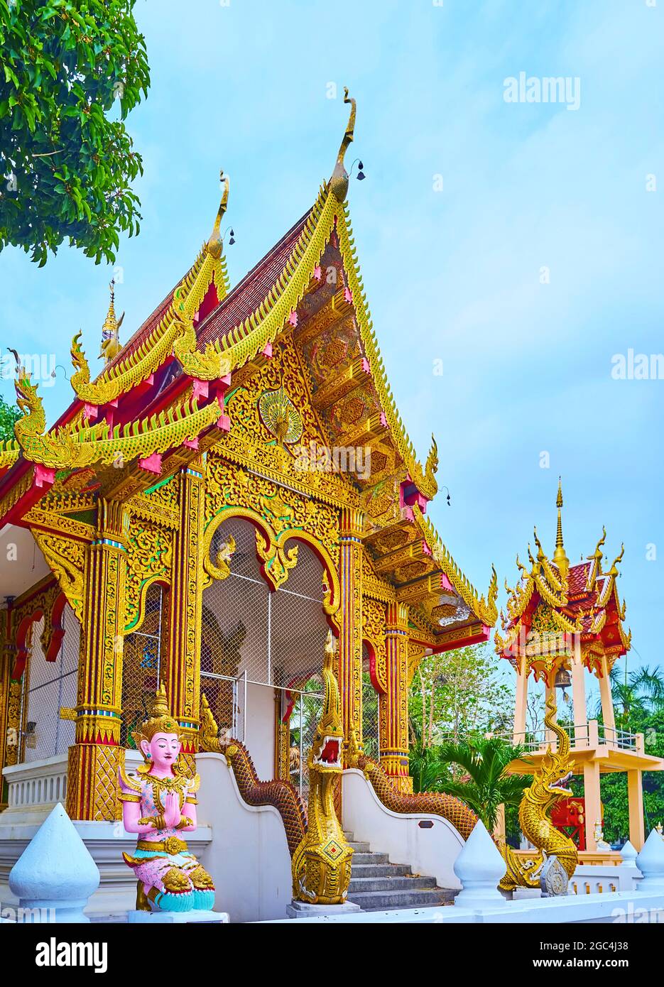 The ornate viharn hall of Wat Sangkharam Temple with pyathat (gable) roof,  fine gilt patterns, carved bargeboards, sculptures of Naga serpents and Dev  Stock Photo - Alamy