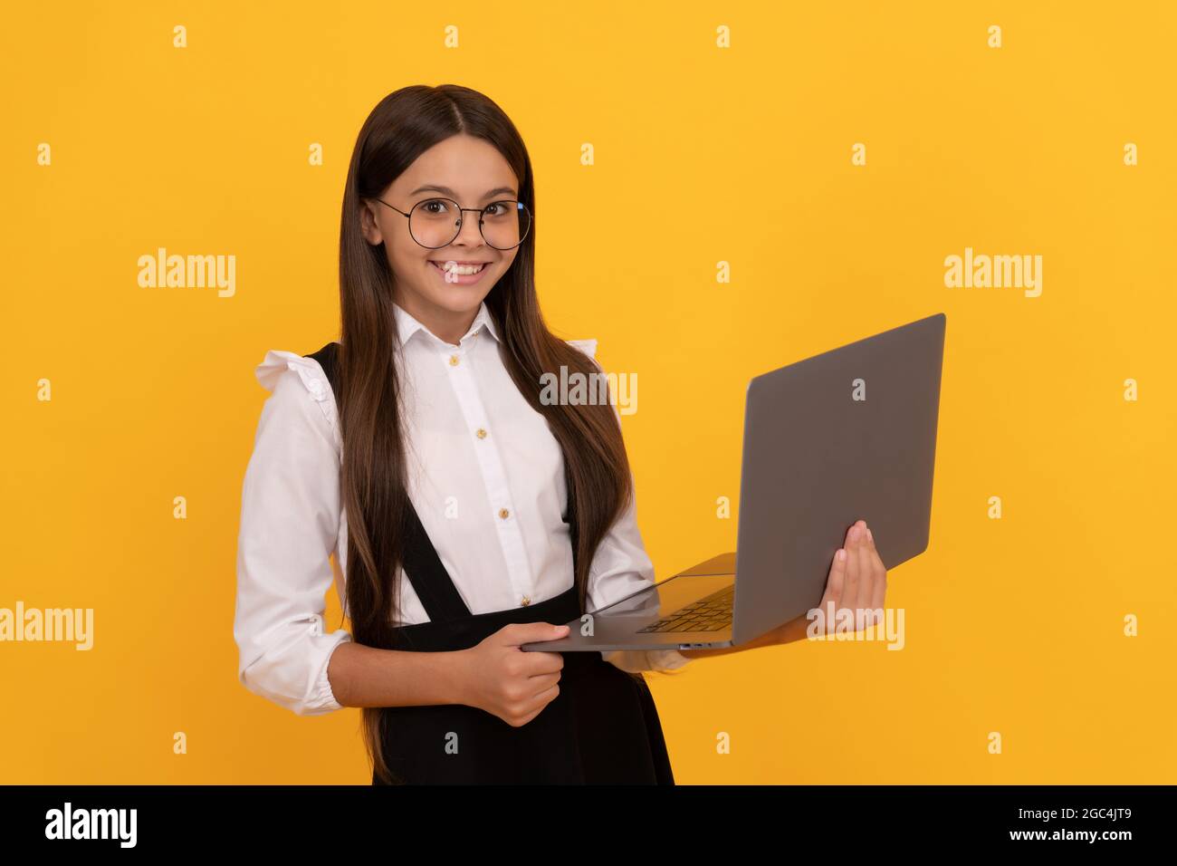 smiling kid in school uniform and glasses study on laptop, computer