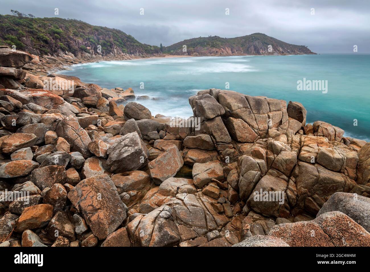 a rocky beach next to a body of water Stock Photo