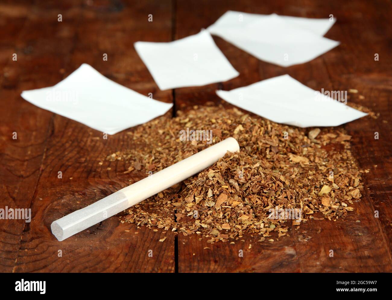 https://c8.alamy.com/comp/2GC59W7/tobacco-and-rolling-paper-on-wooden-background-2GC59W7.jpg