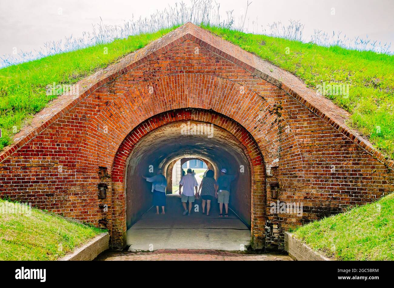 Visitors walk through the postern tunnel at Fort Morgan, July 31, 2021, in Gulf Shores, Alabama. The tunnel is surrounded by the glacis. Stock Photo
