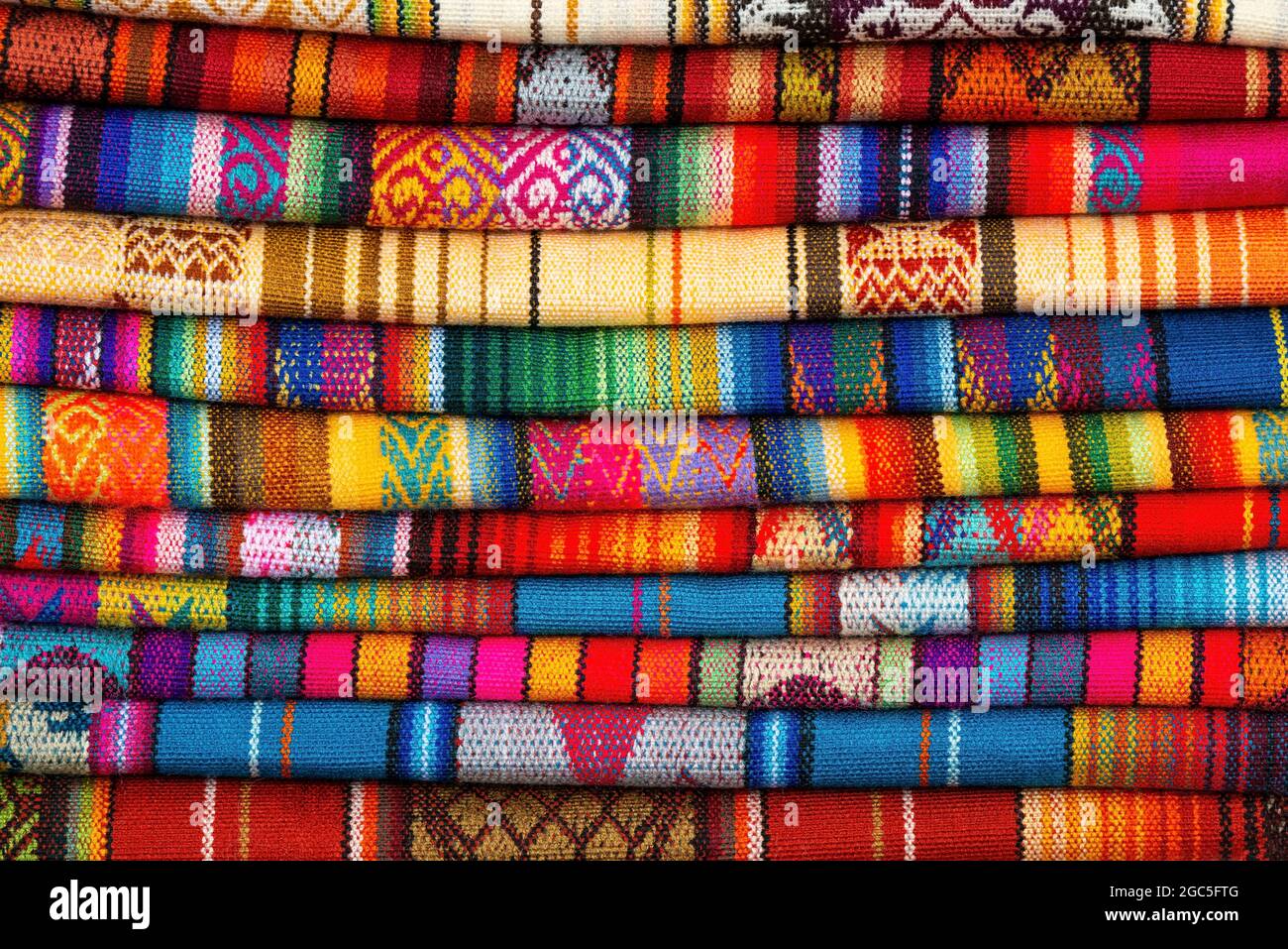Andes textile fabric pile on Cusco handicraft market, Peru. Stock Photo
