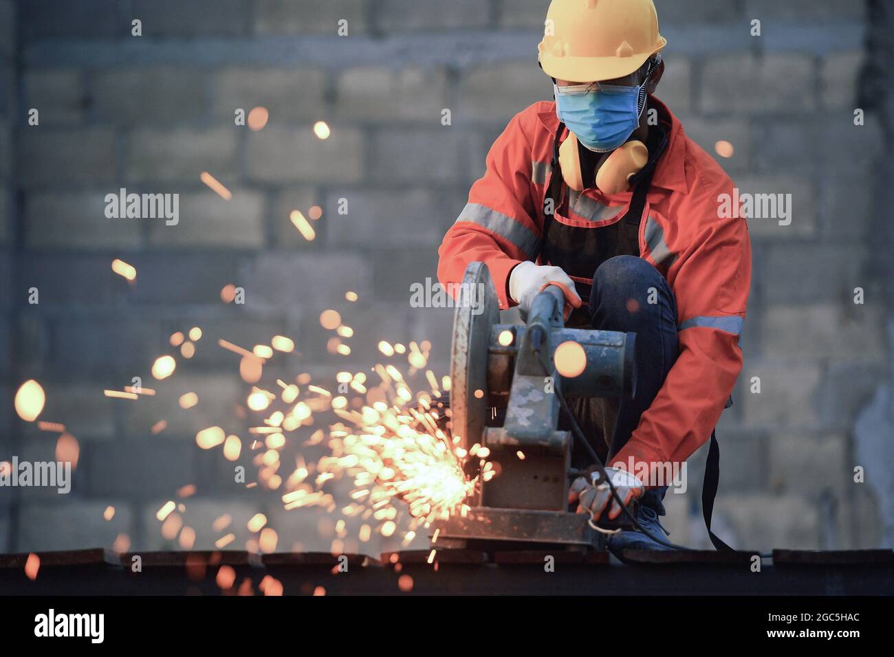 Worker cut steel with cutting machine circular disc cuts off part of ...