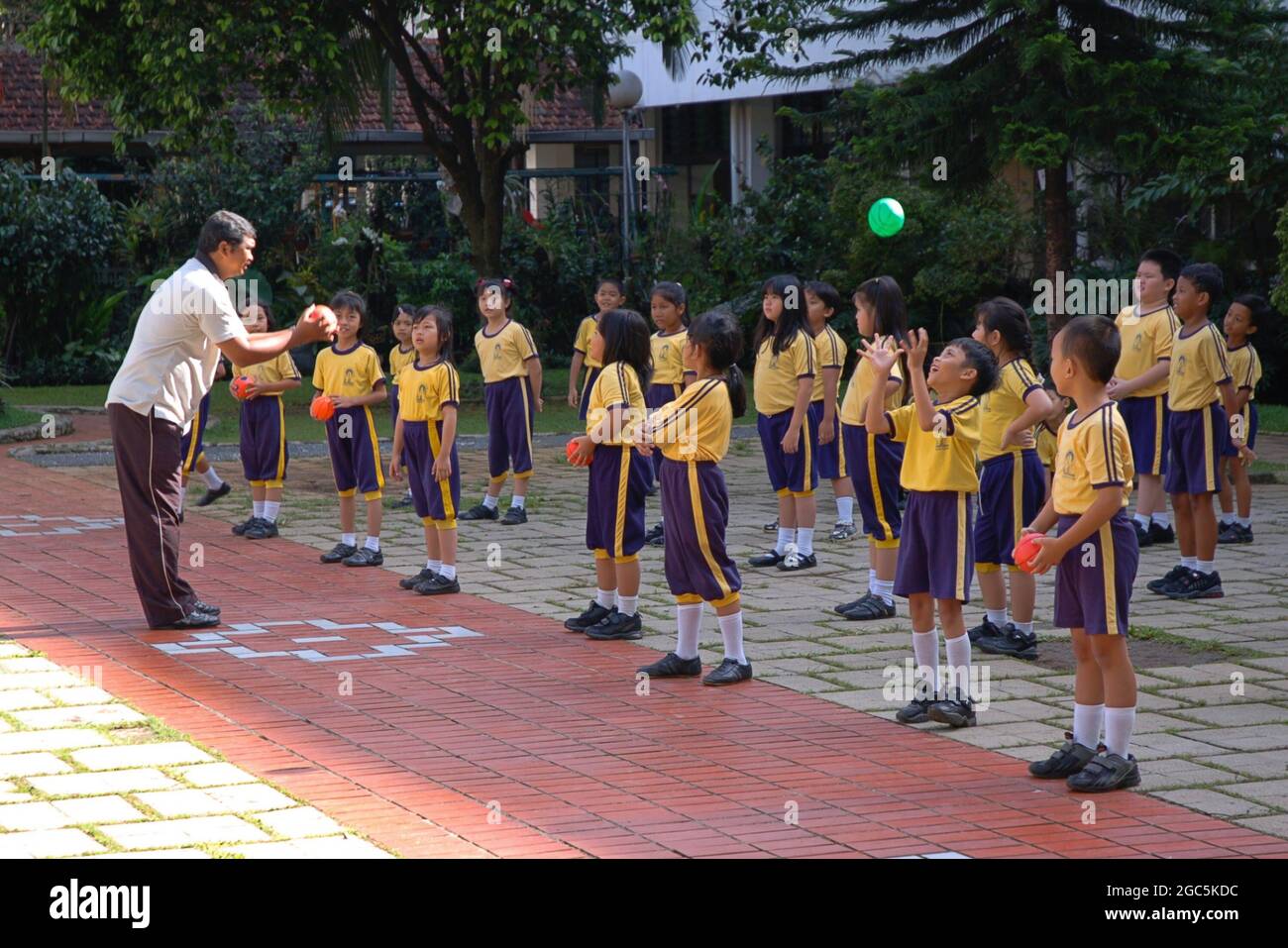 A group of elementary students throw and catch ball in their school