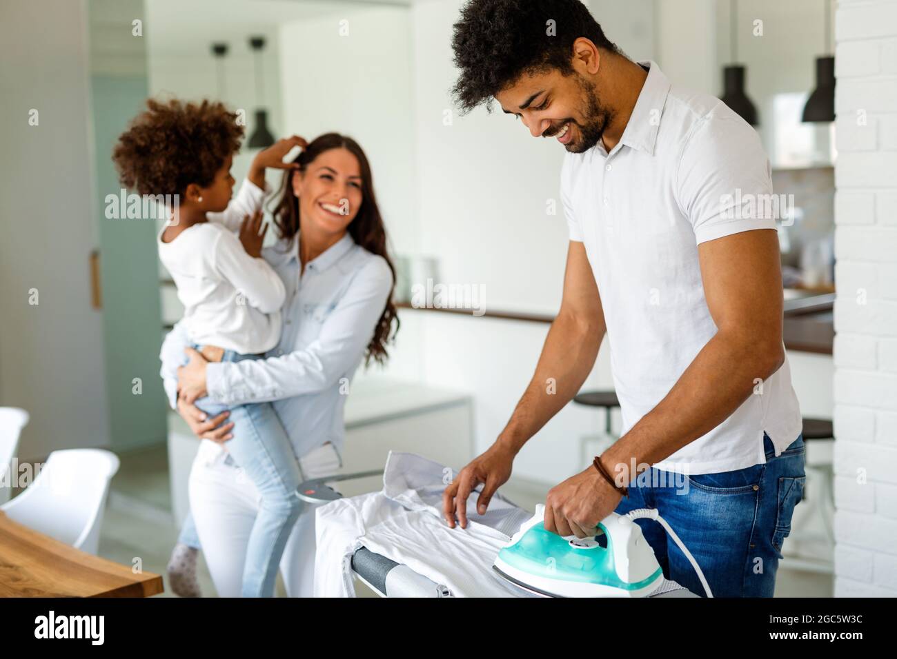 Happy young handsome black man ironing clothes at home. Family happy love concept Stock Photo