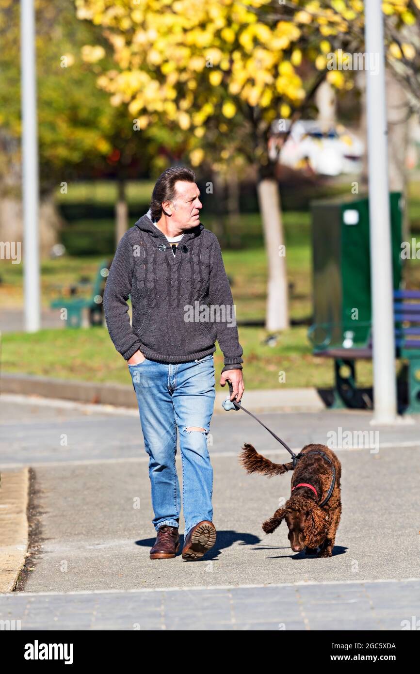 Ballarat Australia /  A man out walking exercising with his dog during Covid 19 restrictions at Lake Wendouree, Ballarat, Australia. Stock Photo