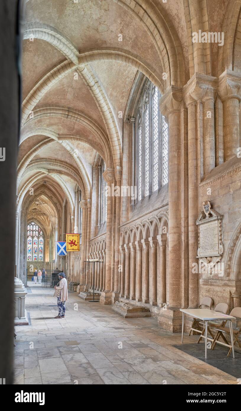 North aisle (with the flags of Mary queen of Scotland at the far end) in the medieval christian cathedral of Peterborough, England. Stock Photo