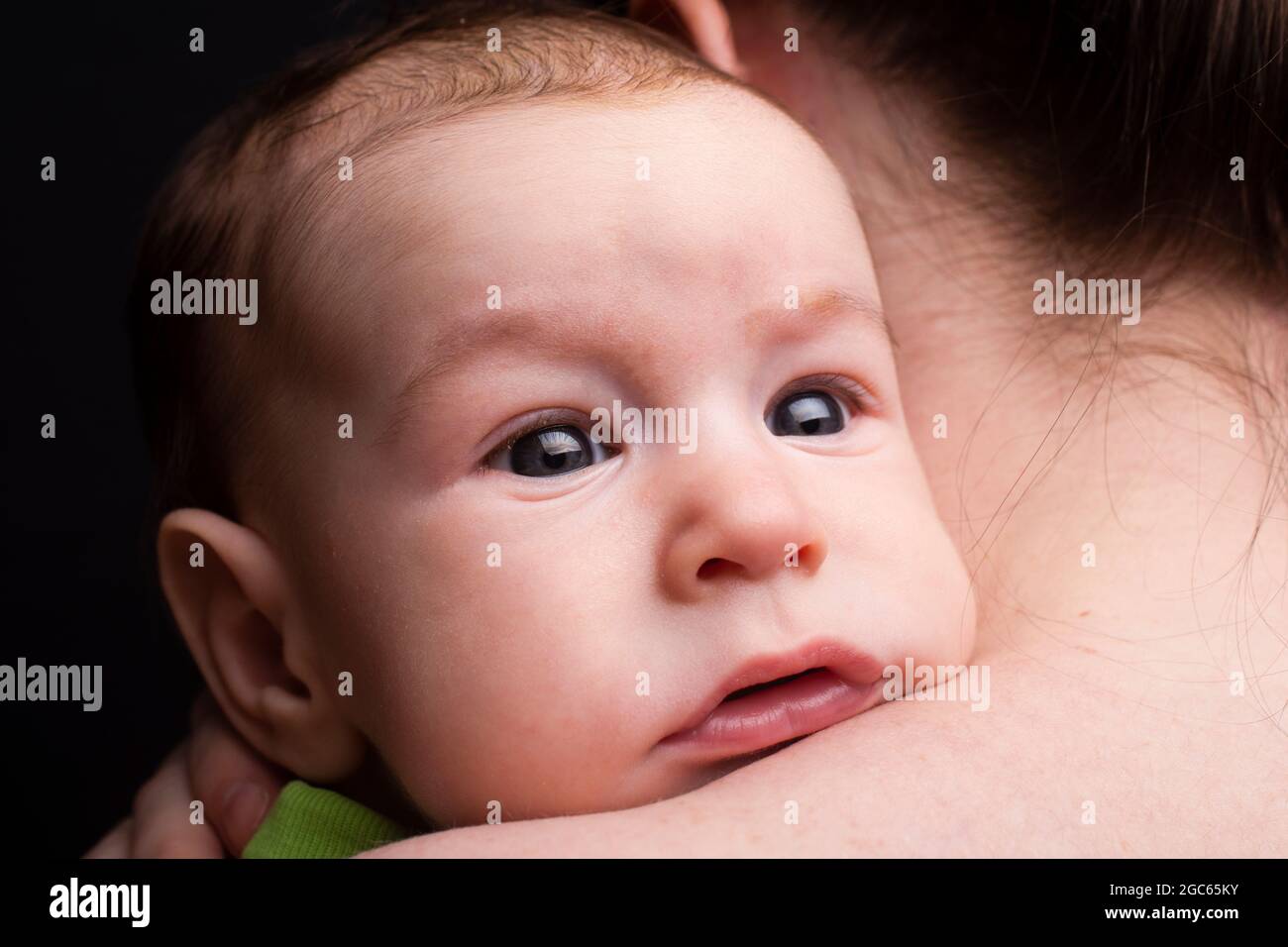 closeup portrait of baby, together with mom. Large glare in the eyes