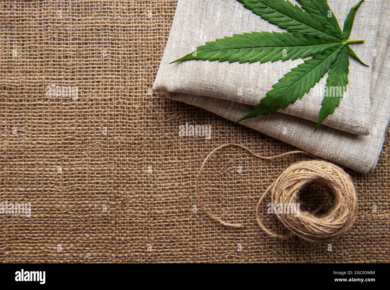 https://c8.alamy.com/comp/2GC65MM/cannabis-leaves-on-the-background-of-coarse-hemp-fabric-2GC65MM.jpg