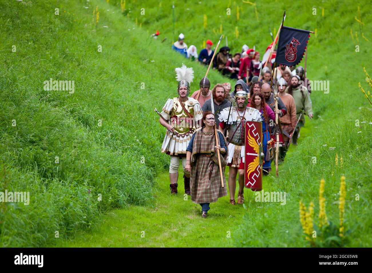 1st August 2021. Norfolk, England. Soldiers Through the Ages event at Castle Rising, the first public event at the 12th Century castle since before the Covid pandemic outbreak.  Led by Queen Boudica, a parade of re-enactors around the castle's moat, representing warriors from Roman Britain through to the two world wars. Stock Photo