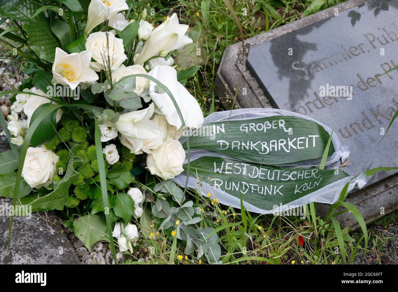 Cologne, Germany. 07th Aug, 2021. A wreath from Wetsdeutscher Rundfunk WDR lies on the gravesite of TV presenter Alfred Biolek at Melaten Cemetery. Here on Friday evening the urn with the ashes of Alfred Biolek was buried after the official closing time of the cemetery in the close circle of friends and family. The gravesite belongs to the Gruber family, with whom Biolek was close friends. Credit: Henning Kaiser/dpa/Alamy Live News Stock Photo