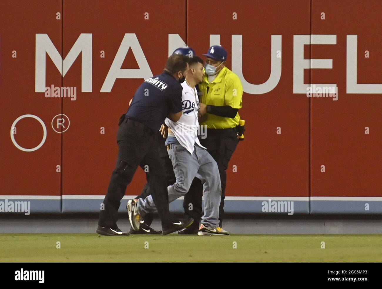 Los Angeles, United States. 07th Aug, 2021. A fan is escorted off the