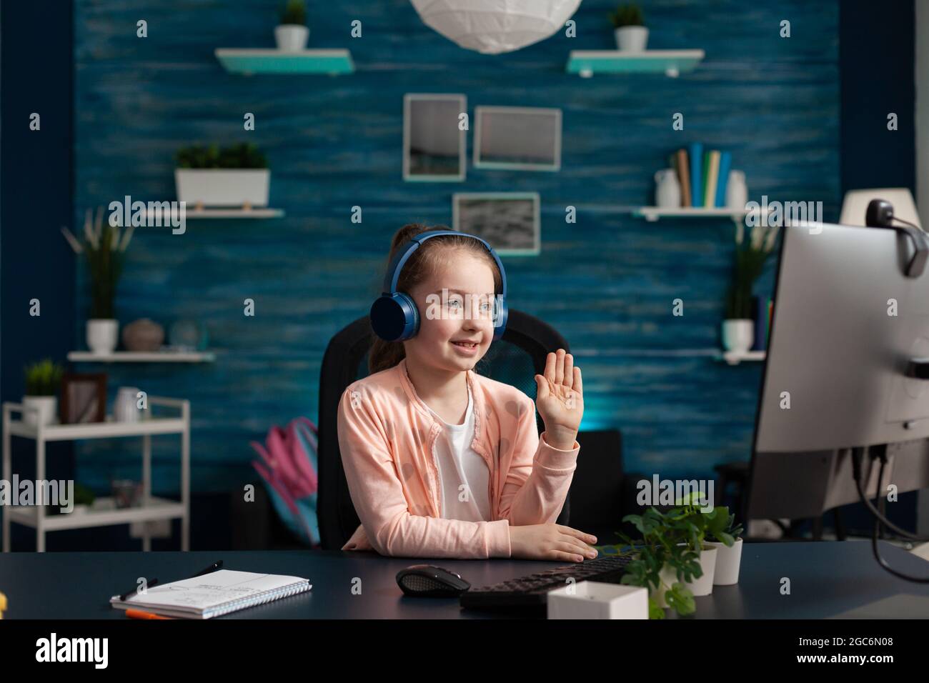 Modern school pupil paying attention to online class while using technology computer internet website and headphones. Clever girl working on education knowledge and digital communication Stock Photo