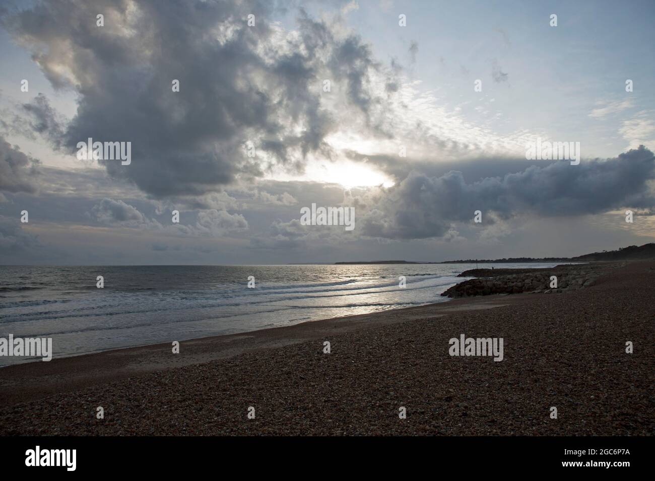 Dark rain clouds gathering over a deserted pebble beach in autumn. Very uninviting Stock Photo